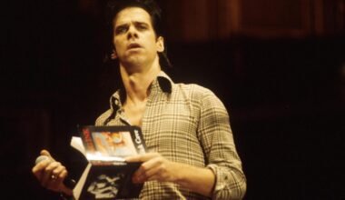 Porträt von Nick Cave, der ein Buch in der Hand hält.