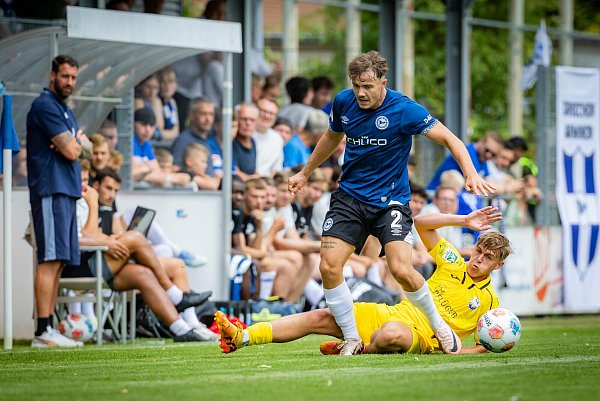 Vor den Augen von Arminia-Trainer Mitch Kniat wird Felix Hagmann von einem Wiedenbrücker Gegenspieler gestoppt. - © Sarah Jonek