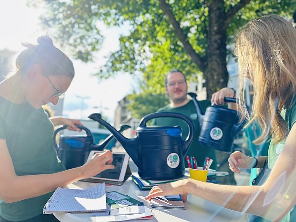 Das Team von "BaumBie wird noch an zwei Donnerstagen zum Abendmarkt mit der Gießkannen-Aktion am Stand weiter um Unterstützende und Interessierte für das Projekt werben. - © Stefan Becker
