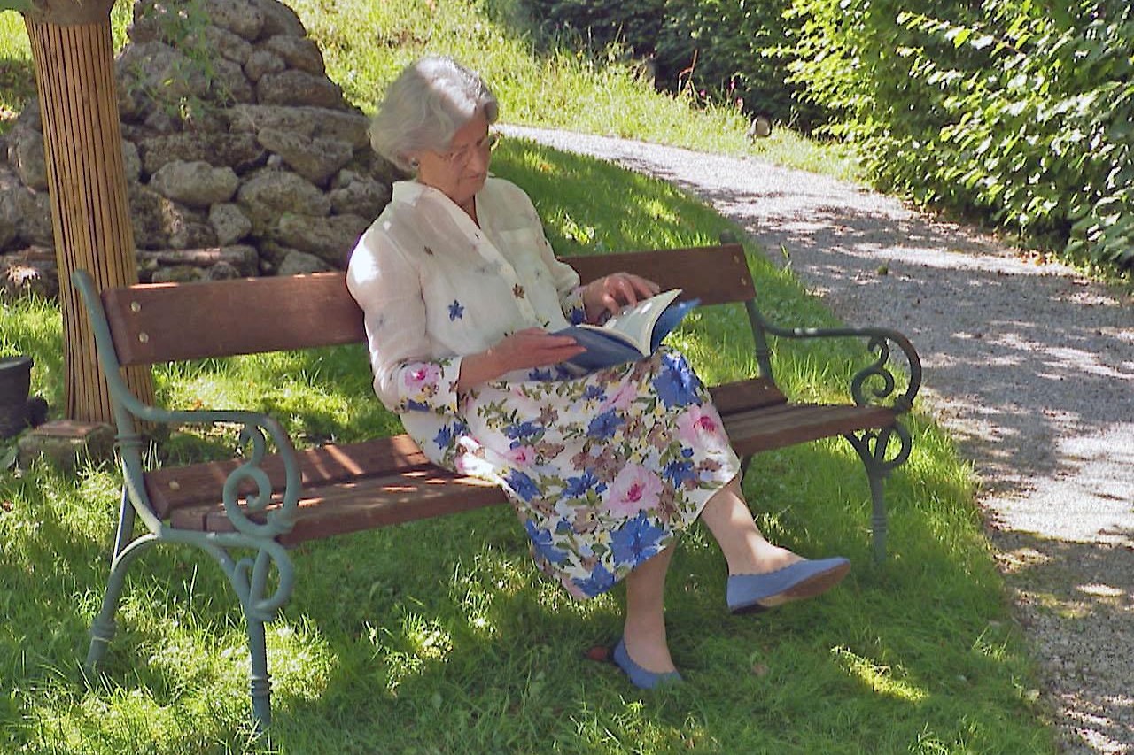 Susanne Kuhn sitzt auf Parkbank im Schatten