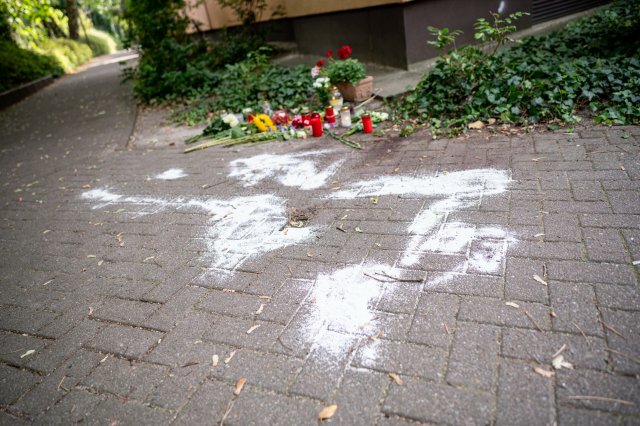 Kerzen und Blumen stehen in Berlin-Zehlendorf an dem Ort, an dem mutmaßlich ein Mann seine Ex-Frau erstochen haben soll.