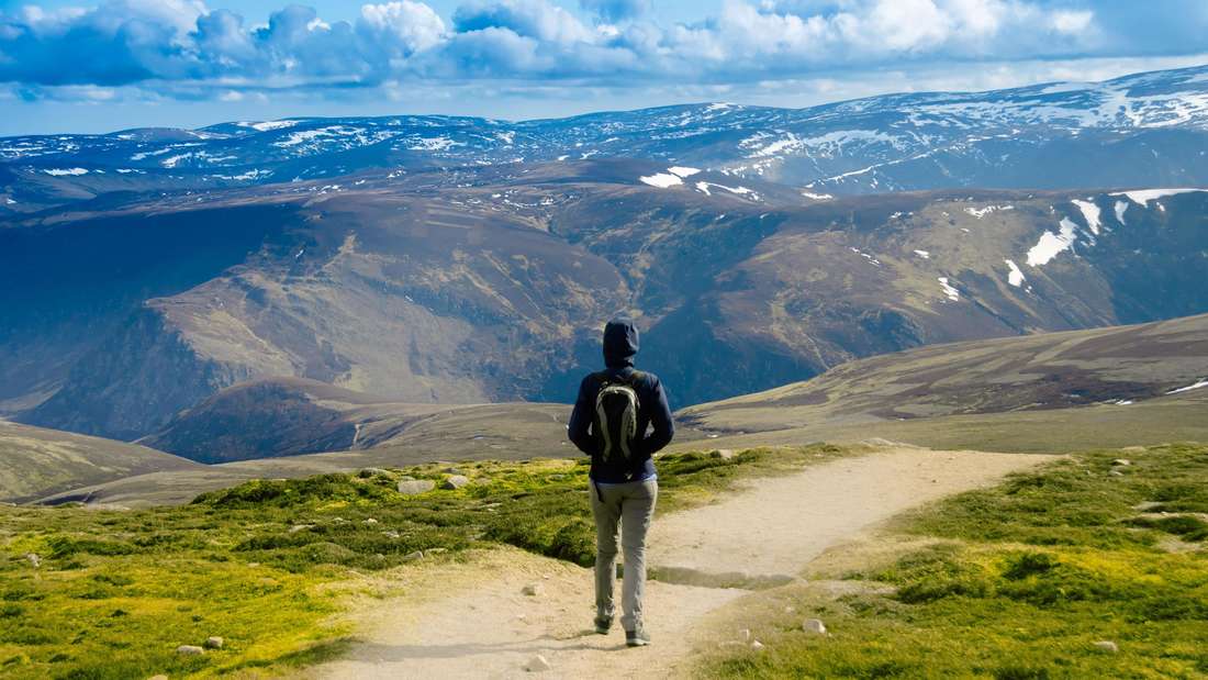Ein Tourist wandert durch den Cairngorms National Park in Schottland, UK.