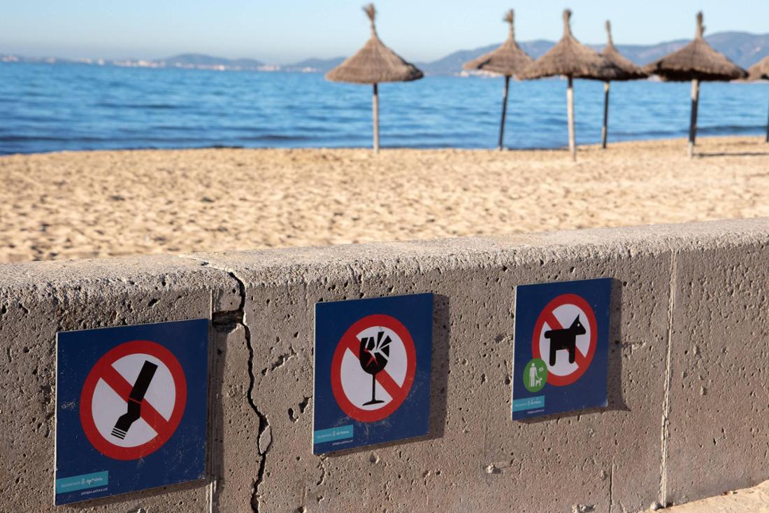 Drei Hinweisschilder weisen darauf hin, was am Strand von Platja de Palma auf Mallorca verboten ist.