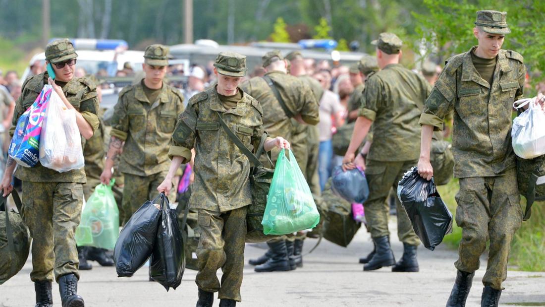 Junge Männer in Uniform tragen Tüten