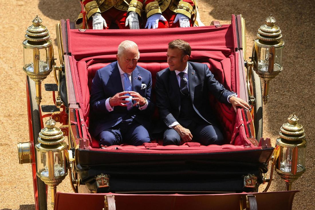 König Charles und Emmanuel Macron in einer Kutsche.