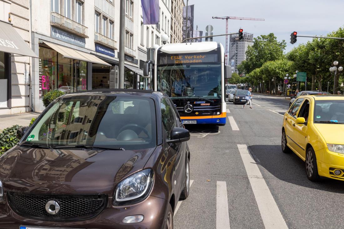 Ein Bus steht auf einer Busspur, vor ihm ein parkendes Auto. Um weiterzufahren, muss der Fahrer die Spur verlassen. 