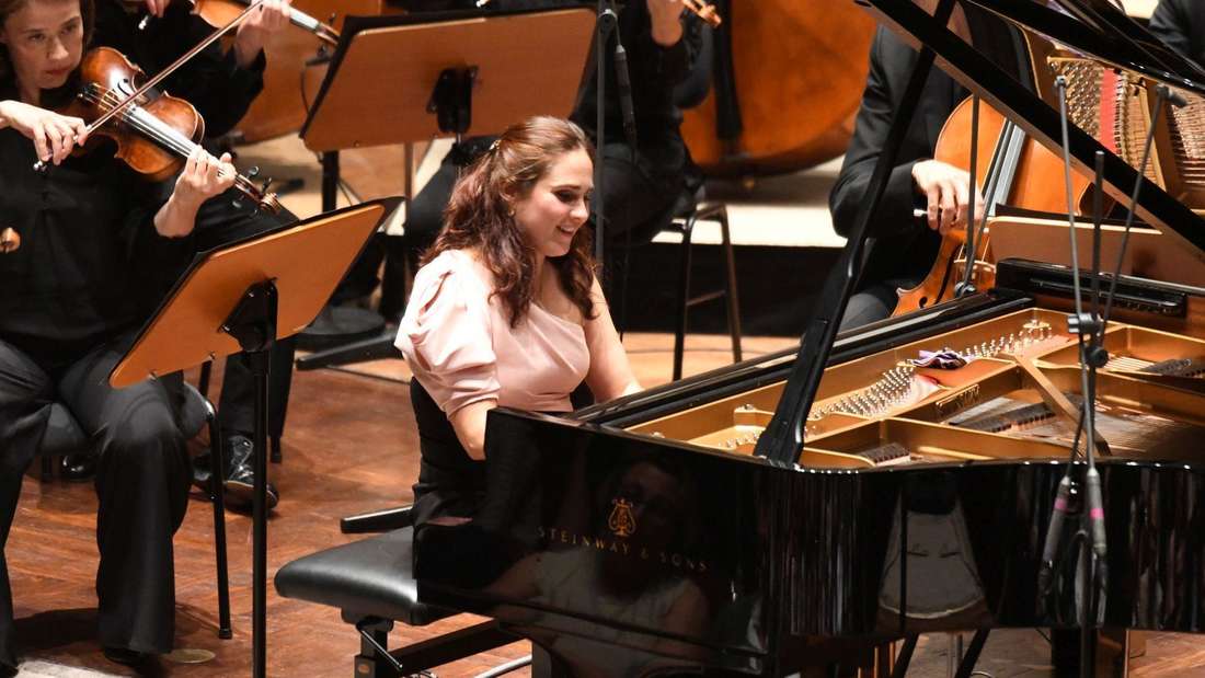 Die Pianistin am Flügel, hinter ihr das Orchester.