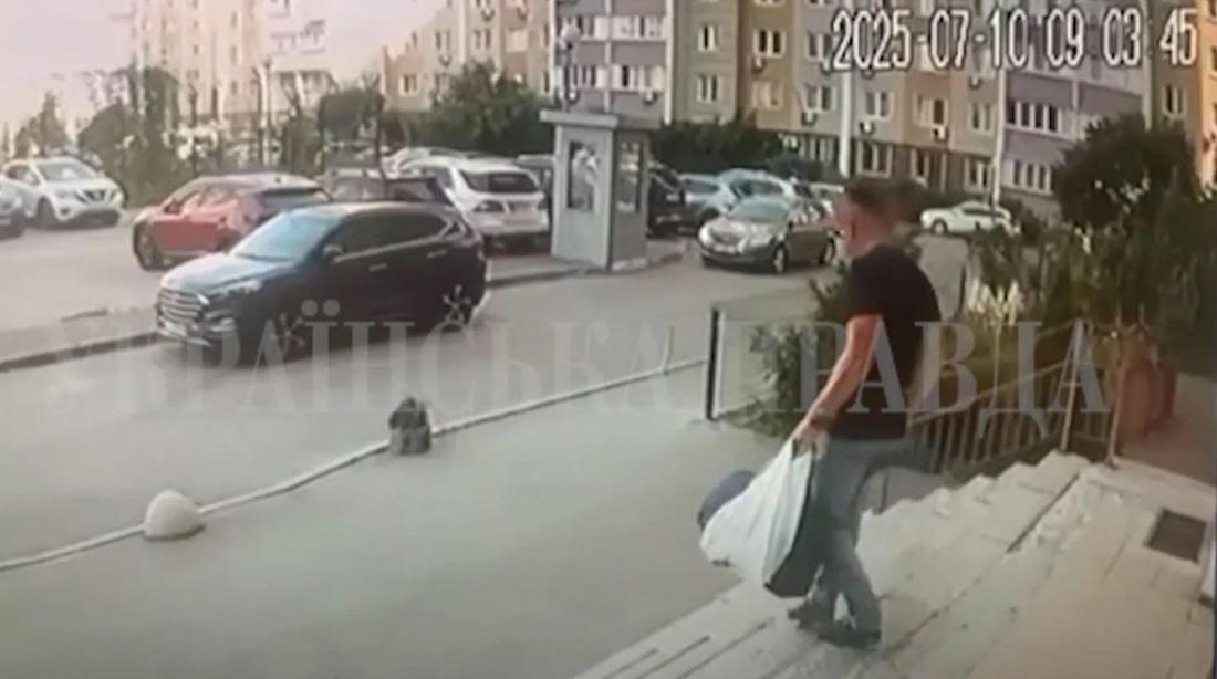 Ein Mann geht eine Truppe hinunter. Gegenüber stehen einige Autos auf einem Parkplatz. 