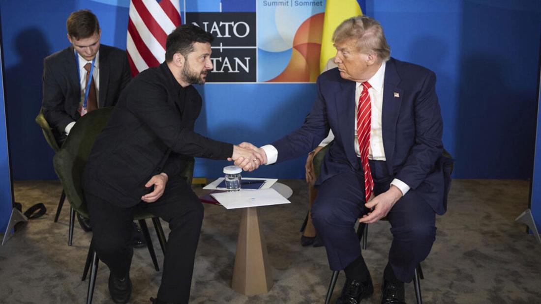 Wolodymyr Selenskyj (l.) und Donald Trump sitzen nebeneinander und reichen sich die Hand