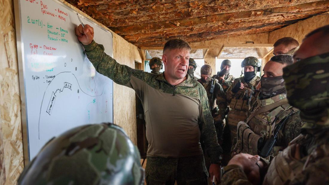 Soldaten stehen in einem Unterstand um eine Tafel herum
