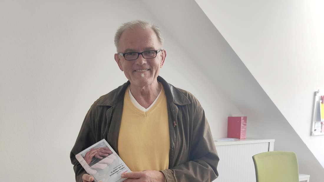 Ein Mann hält ein Buch.