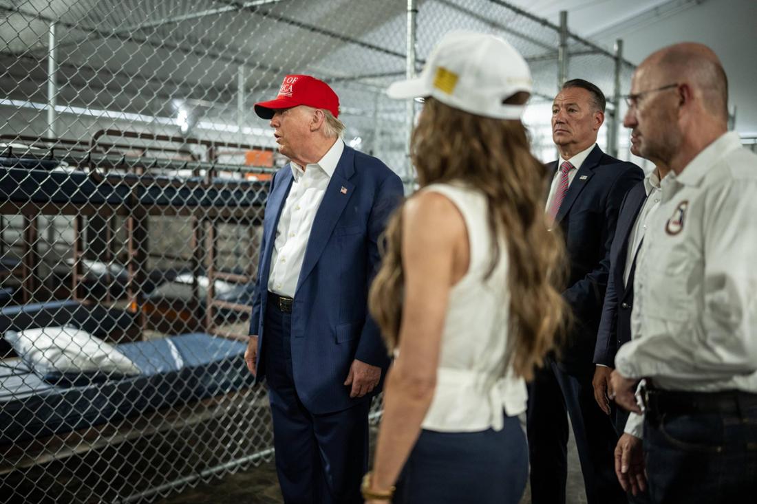 Donald Trump auf Besuch in „Alligator Alcatraz“ vor einem Maschendrahtkäfig mit einfachen Betten.