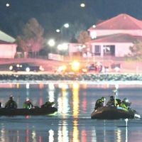 Rettungskräfte befinden sich auf Rettungsbooten auf einem Fluss. 