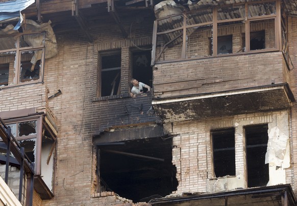 epaselect epa12228455 A man looks out of a broken window at the site of a drone strike in Kyiv, Ukraine, 10 July 2025, amid the ongoing Russian invasion. At least two people were killed in Kyiv, and m ...