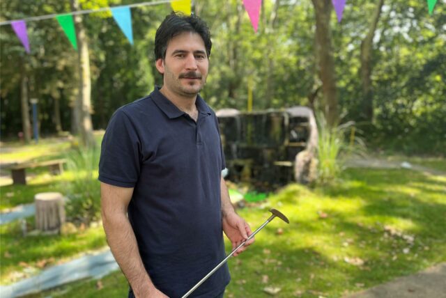 Achmet Gül steht mit einem Minigolfschläger in der Hand auf seiner selbst renovierten Minigolfanlage in Castrop-Rauxel.