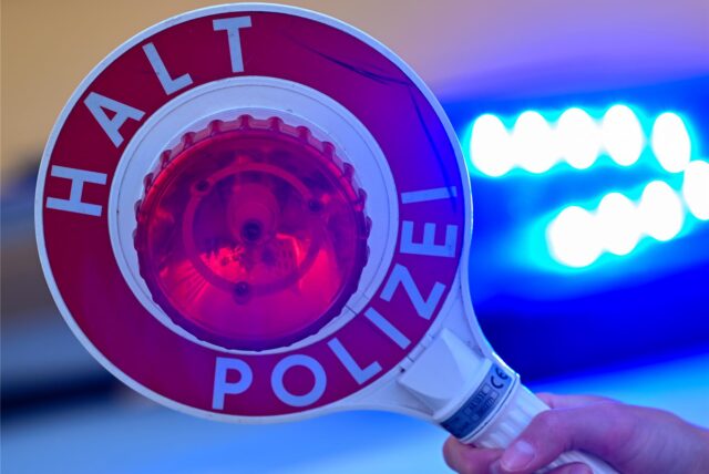 Eine Polizeikelle wird hochgehalten. (Symbolbild)