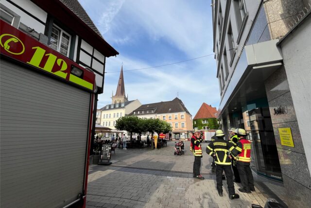 Feuerwehrleute stehen vor dem Wohnhaus am Markt 9 in Unna
