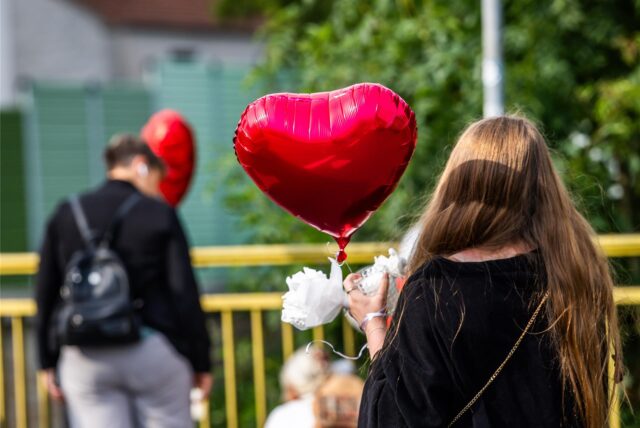 Ein Mädchen steht mit einem Herz-Luftballon auf einer Brücke in Lütgendortmund.