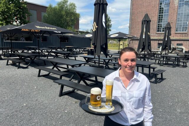 Tanja Wolschke mit Tablett und Bier im Biergarten auf der Kokerei Hansa.