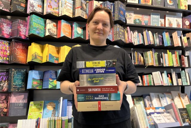 Buchhändlerin Natalia Tokar-Khan mit einem Bücherstapel.