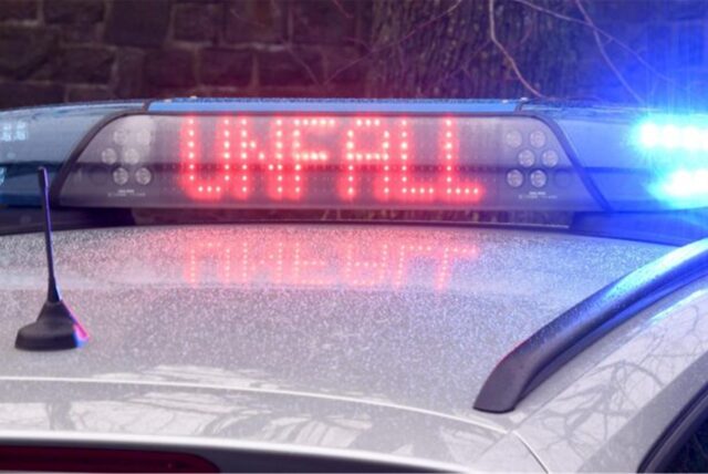 Blaulicht und das Schild „Unfall“ leuchten auf einem Streifenwagen.