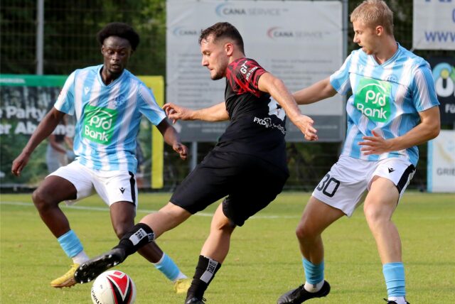 Drei Spieler kämpfen um den Ball.