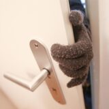 Eine Person, die Stoffhandschuhe trägt, betritt eine fremde Wohnung