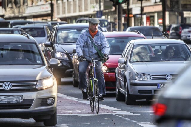 Ein Radfahrer am Wall umringt von Autos