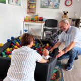 Martin Solty vom Pflegekinderdienst und eine Pflegemutter sitzen vor dem Bällebad in der Wohnung vom Jugendamt im Stadtfenster.