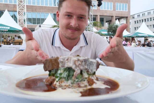 Reporter Tim Hübbertz präsentiert ein Gericht auf der Gourmedo auf dem Dortmunder Friedensplatz.