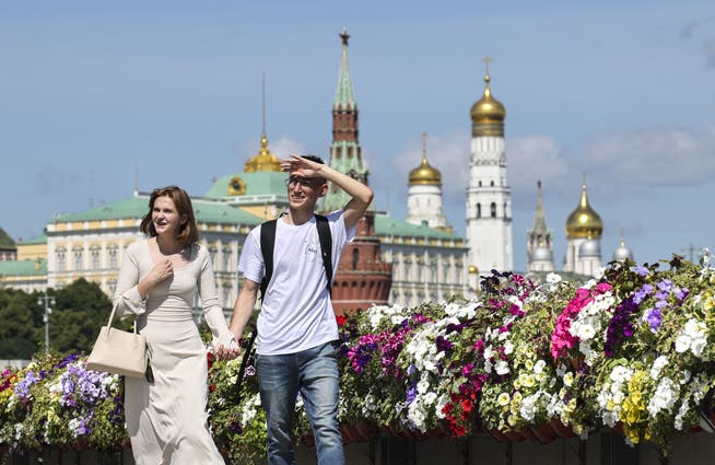Ein Paar spaziert auf einer mit Blumen geschmückten Brücke beim Kreml im Moskau. Der üppige Blumenschmuck ist Teil des Programms «Sommer in Moskau» zur Verschönerung des städtischen Raums.