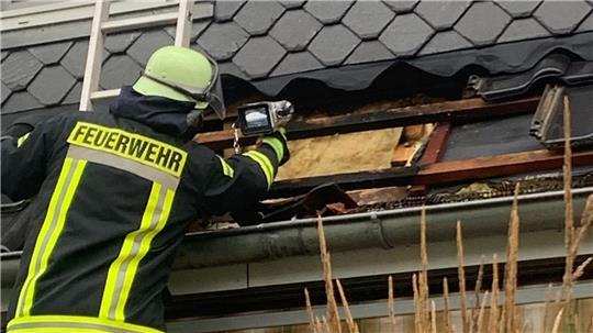 Die Feuerwehrleute kontrollieren die Brandstelle und suchen nach Glutnestern.