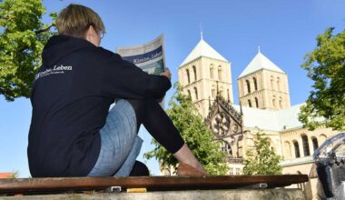 Junge Frau mit Kirche+Leben vor dem Paulusdom Foto: Michael Bönte
