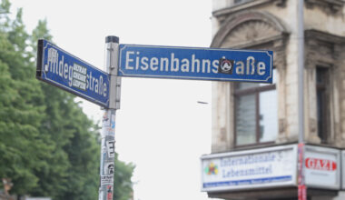 Straßenschild vor Hausfassade.