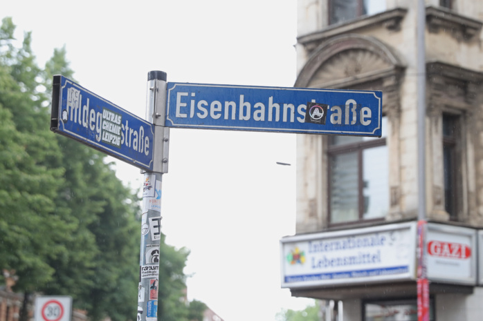 Straßenschild vor Hausfassade.