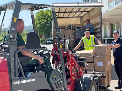 Verladen in Emmerthal Hilfsgüter für die Ukraine: der stellvertretende Ortsbrandmeister Phil Kreibaum (auf dem Frontlader) und Gemeindebrandmeister Thomas Feldmann und Interhelper Gerald Krause.