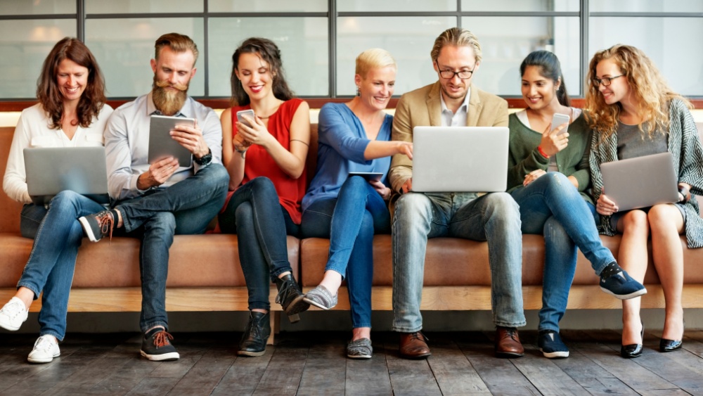 People looking at their laptops and smartphones.