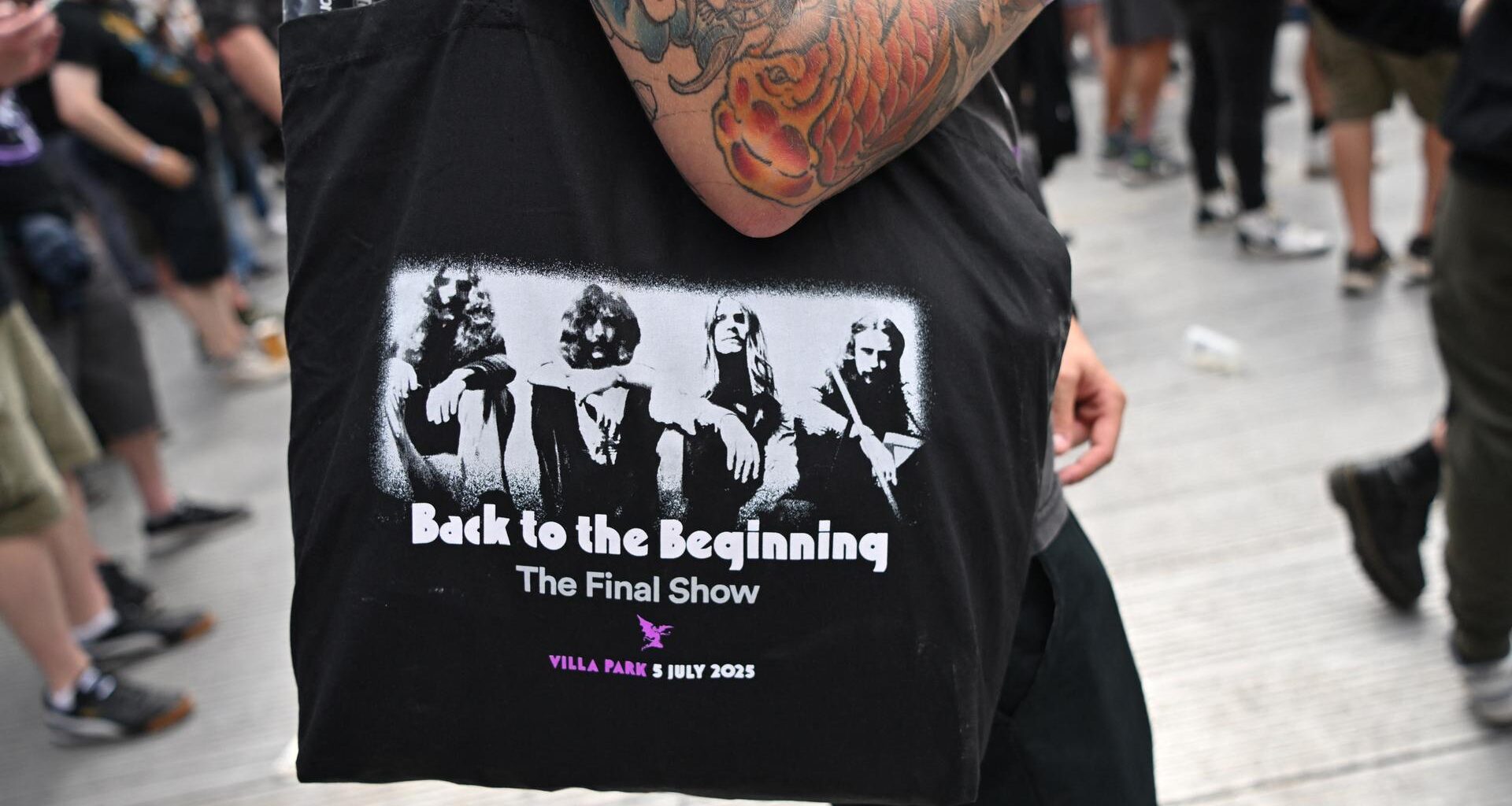 Ein Fan trägt eine Tasche mit dem Aufdruck von Black Sabbath aus der Gründungszeit und der Aufschrift "Back to the Beginning".