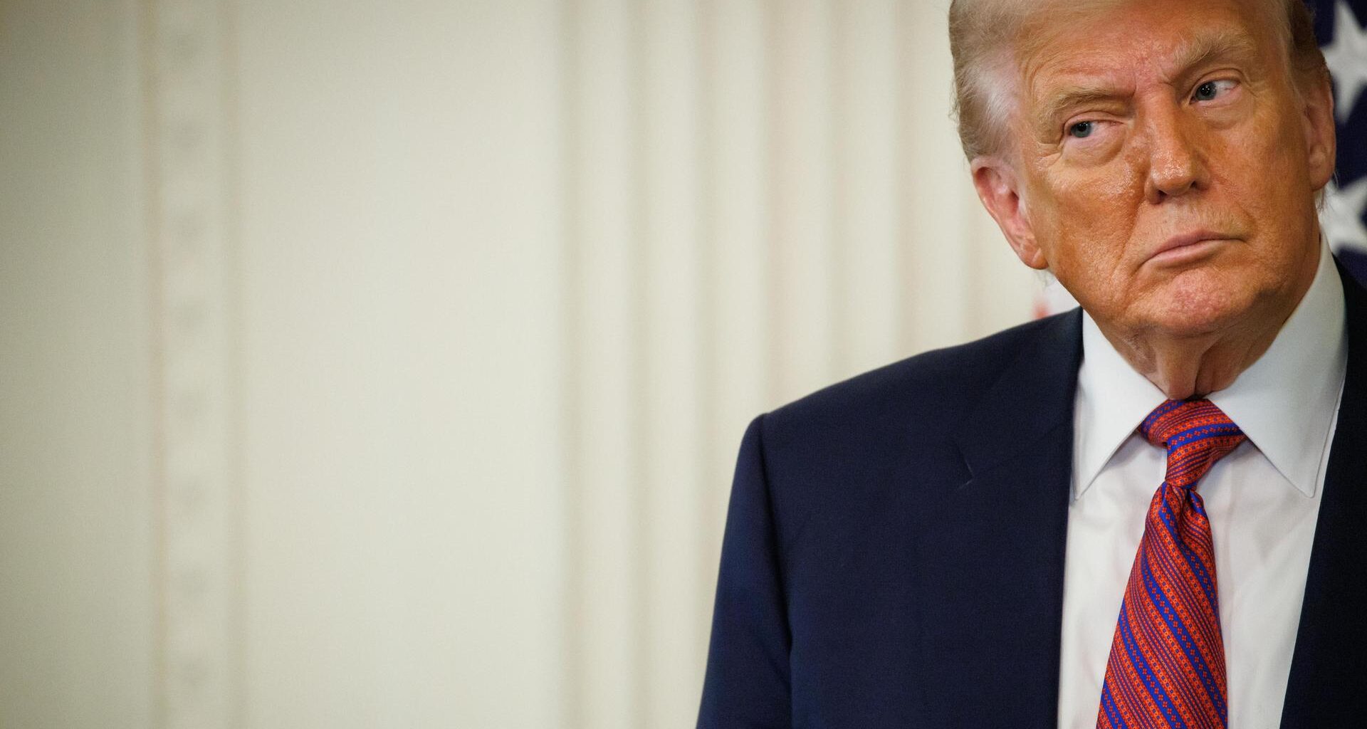 US-Präsident Donald Trump in Anzug und mit Krawatte vor einem hellen Hintergrund schaut skeptisch zur Seite