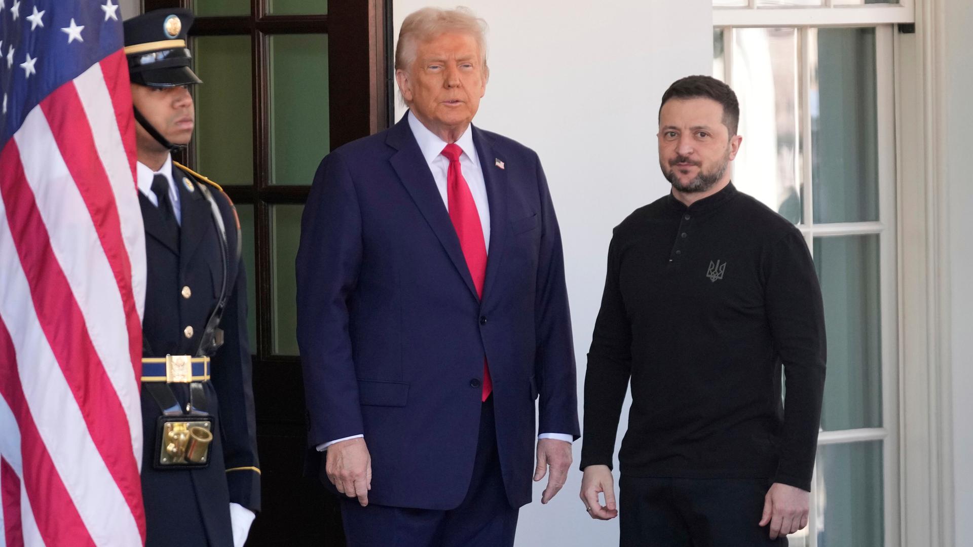 Donald Trump und Wolodymyr Selenskyj stehen gemeinsam neben einer US-Flagge.