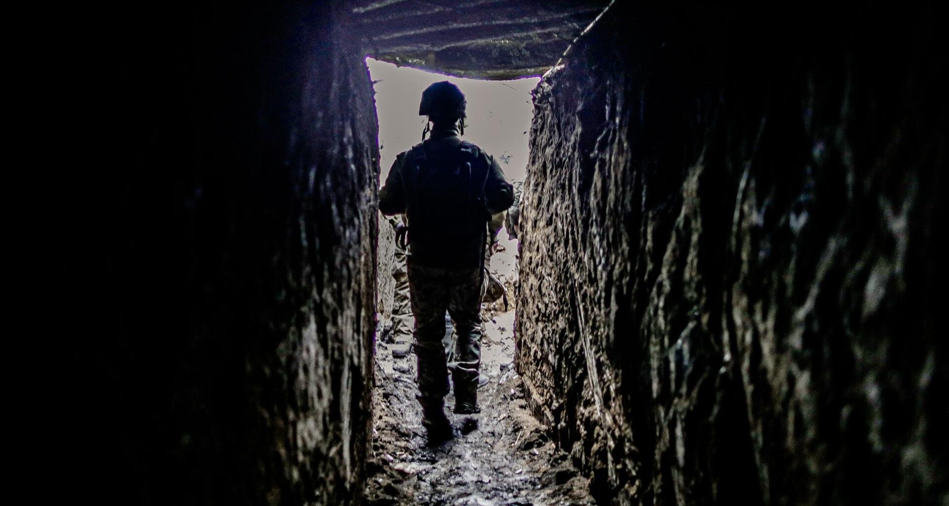 Ein ukrainischer Soldat geht durch einen Schützengraben.