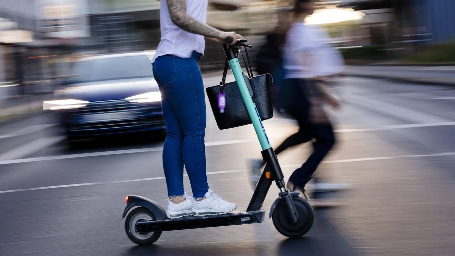 E Scooter Fahrerin in der Kölner Innenstadt: Klappbare E-Tretroller dürfen kostenlos in Bus und Bahn mitgenommen werden.