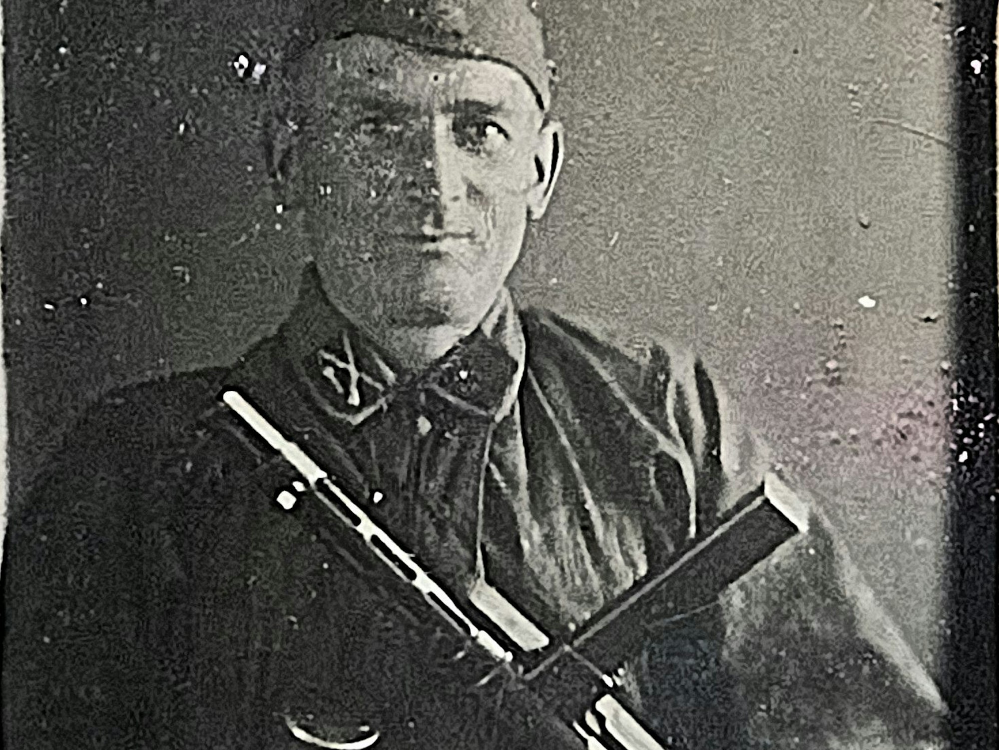 Ein altes Schwarz-Weiß-Foto zeigt Carlhans Jung in der Uniform einer SS-Formation, auch eine Maschinenpistole ist zu sehen.