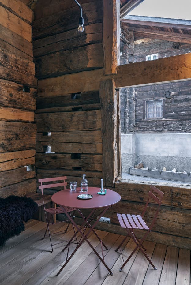 In der zur Dorfstrasse halboffenen Loggia ist das alte Gebälk sichtbar geblieben.