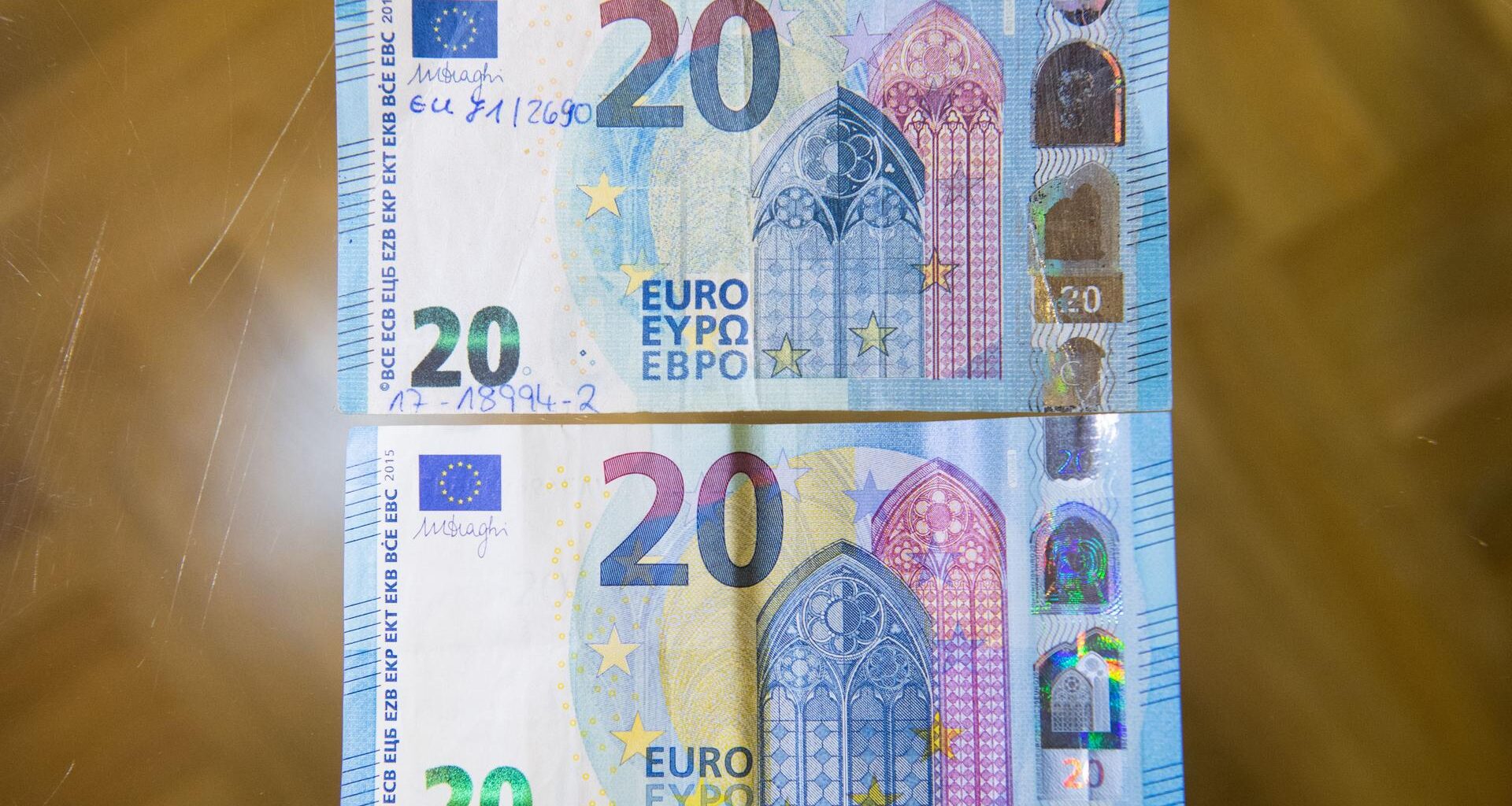 Ein gefälschter und sichergestellter 20-Euro-Schein (oben) und ein echter 20-Euro-Schein liegen zum Vergleich auf einem Tisch in der Deutschen Bundesbank.