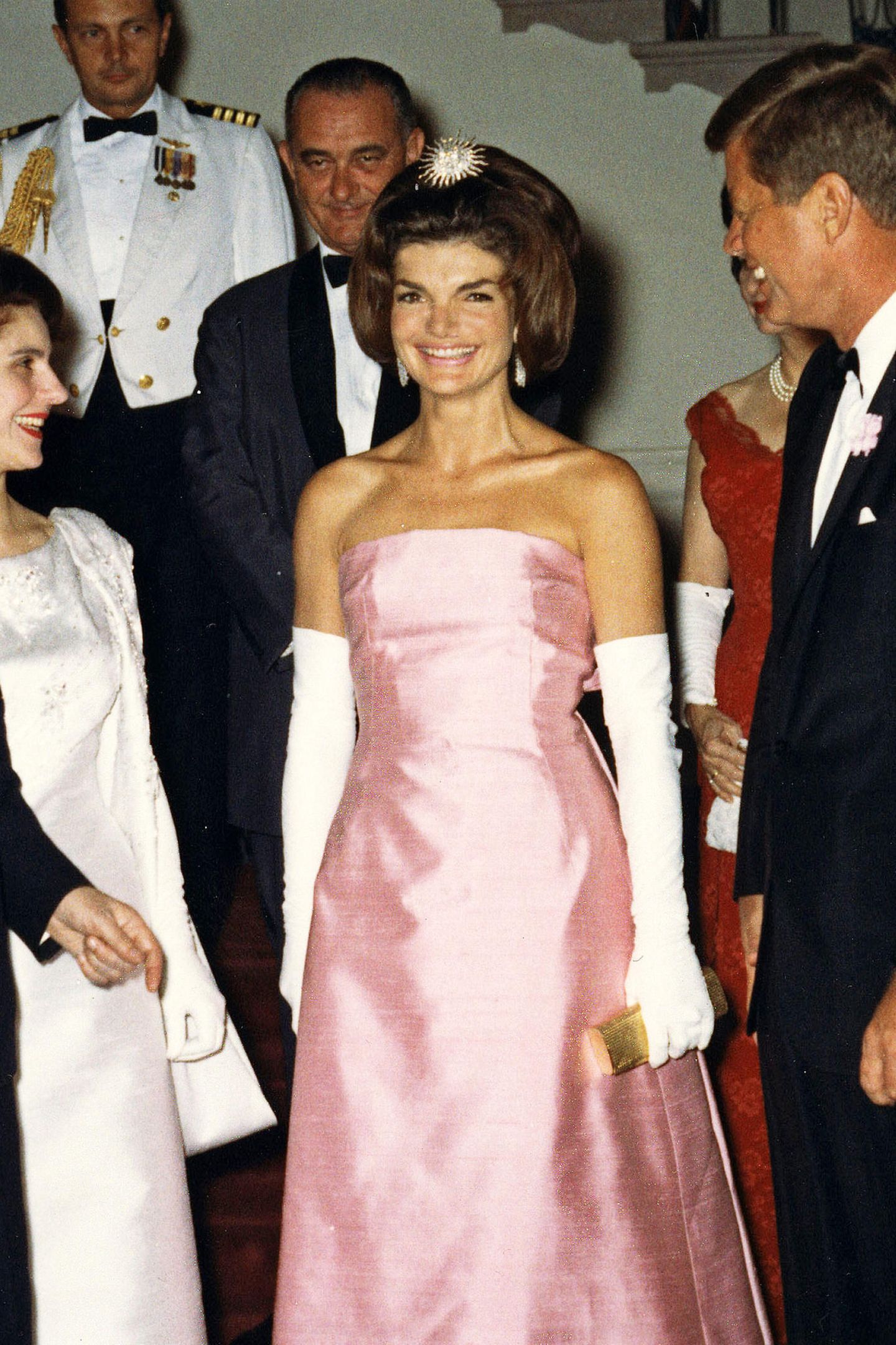 Jacqueline "Jackie“ Lee Bouvier Kennedy Onassis war die Ehefrau des 35. US-Präsidenten John F. Kennedy und damit vom 20. Januar 1961 bis zum 22. November 1963 die First Lady der Vereinigten Staaten. Sie zählte zu einer stylischsten Frauen ihrer Zeit und setzte viele Trends, die mitunter bis heute Bestand haben. Sie setzte besonders gerne auf farbige Looks, wie hier im Jahr 1962 bei einem Event im Weißen Haus. Das trägerlose Kleid stammt aus der Feder des berühmten Designers Christian Dior. 