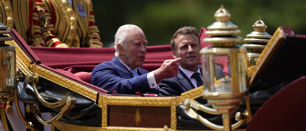 Der britische König Charles III. und Frankreichs Präsident Emmanuel Macron im Gespräch während der Kutschenprozession zum Schloss Windsor.  