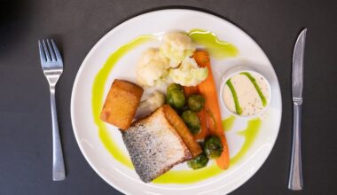 Wildlachs angerichtet mit Blumenkohl und Kartoffeln auf einem Teller
