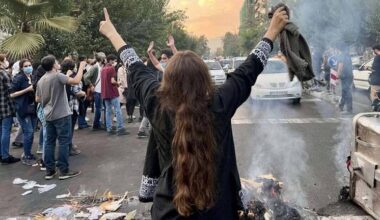 Eine Frau steht bei Protesten in der iranischen Hauptstadt Teheran ohne das vorgeschrieben Kopftuch auf einer Staße und streckt die Arme in die Luft