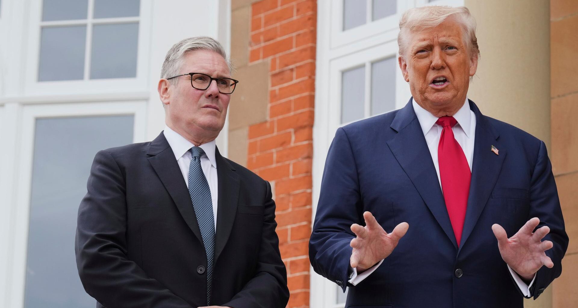 US-Präsident Trump bei einem Treffen mit dem britischen Premierminister Starmer in Schottland. Die beiden stehen nebeneinander, Trump gestikuliert.
